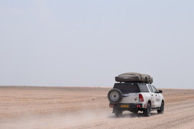 Jeep mit Dachzelt fährt durch Wüste - Namibia Familienurlaub