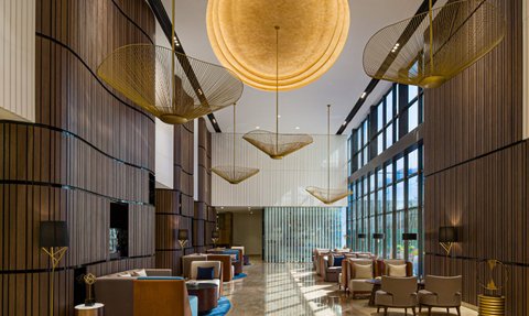 Der elegante Lobbybereich mit modernen Möbeln und großen Fenstern, die viel Tageslicht hereinlassen.