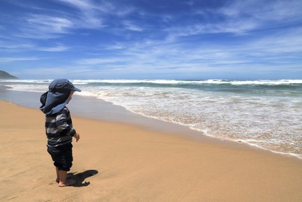 Kind steht an der Küste und blickt aufs Meer – Garden Route mit Kindern