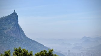Der Christusstatue thront majestätisch auf einem Hügel, umgeben von üppigem Grün und bietet einen atemberaubenden Blick auf die Stadt.