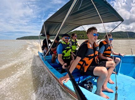 Eine Familie genießt eine Bootsfahrt durch den Bako Nationalpark – Malaysia & Borneo Familienreise
