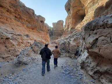 Ein Kind und ein Guide laufen gemeinsam durch einen Canyon - Namibia Rundreise mit Kindern