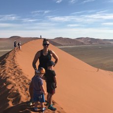 Eine Mutter steht mit zwei Kindern auf einer Sanddüne - Namibia Rundreise mit Kindern
