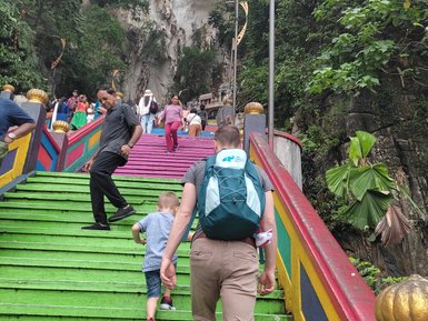 Besucher steigen die bunte Treppe zu den Batu-Höhlen hinauf – Malaysia & Borneo mit Kindern
