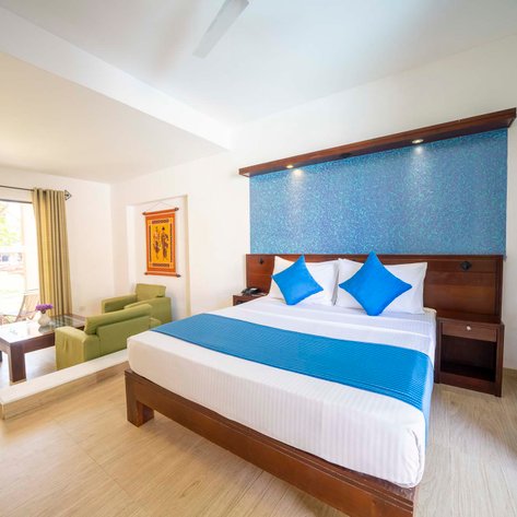 Ein helles Zimmer mit einem großen Bett, blauen Kissen und einem modernen, minimalistischen Design, das Gemütlichkeit ausstrahlt.