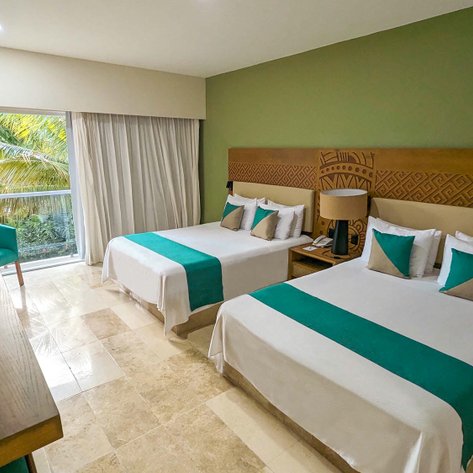 Ein modernes Hotelzimmer mit zwei Betten, dekoriert in sanften Farben und einem Blick auf tropische Pflanzen durch große Fenster.