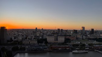 Der Sonnenuntergang über Buenos Aires taucht die Stadt in warmes Licht, während die Silhouetten der Gebäude sichtbar werden.