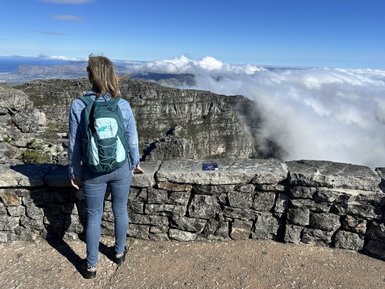 Frau blickt über die Stadt und Küste vom Tafelberg – Südafrika mit Kindern