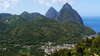 Die beeindruckenden Pitons erheben sich majestätisch über die üppige grüne Landschaft von St. Lucia und dem blauen Ozean.