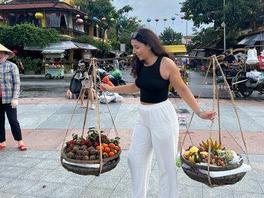 Mädchen trägt frisches Obst in den Straßen von Hoi An – Vietnam Familienreise