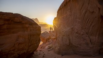 Kids blicken auf Sonnenuntergang in der Wüste Wadi Rum zwischen den Felsen - Jordanien Rundreise mit Kindern