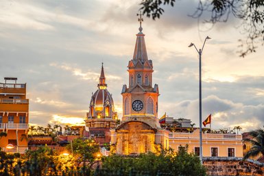 Die beeindruckenden Türme der Stadt Cartagena erstrahlen im warmen Licht der Abenddämmerung, umgeben von historischen Gebäuden.