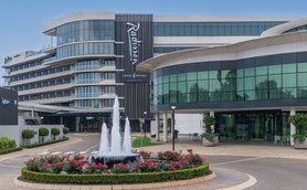 Das Radisson Hotel in Johannesburg zeigt eine moderne Architektur mit großen Fenstern und einem eleganten Eingangsbereich.