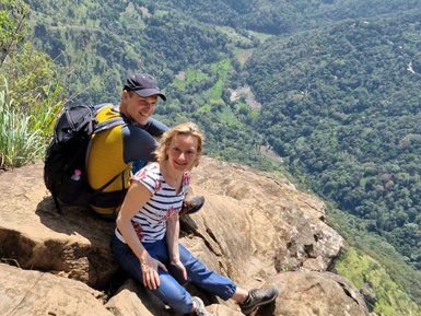 Zwei Teenager sitzen auf einem Felsen und blicken in die grüne Landschaft bei Ella – Sri Lanka mit Kindern
