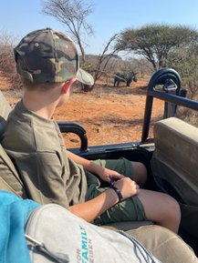 Kind schaut gespannt aus dem Safari-Jeep auf ein Nashorn im Makutsi Game Reserve – Südafrika Familienreise