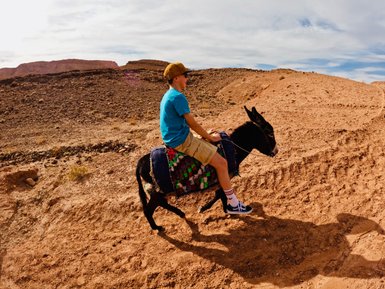 Junge genießt eine spannende Esel-Tour durch die historischen Landschaften von Aït Ben Haddou – Familienurlaub in Marokko