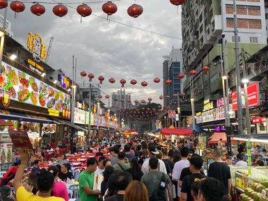 Die belebte Jalan Alor in Kuala Lumpur erstrahlt am Abend mit Streetfood-Ständen – Malaysia & Borneo Familienreise