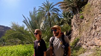 Eltern spazieren im Dorf Misfat Al Abriyeen – Oman Familienreise