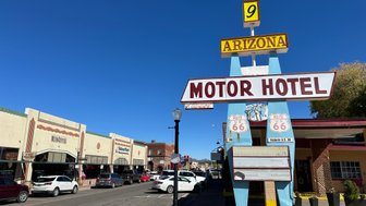 Ein farbenfrohes Schild des Motorhotels in Arizona, das an der berühmten Route 66 steht, unter strahlend blauem Himmel.