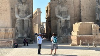 Reiseleiter gibt Erklärungen vor monumentalen Statuen im Tempel von Luxor – Ägypten Reise mit Kindern