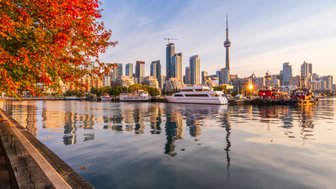 Ein malerischer Blick auf den Toronto-Hafen, umgeben von leuchtend roten Herbstblättern und modernen Wolkenkratzern.