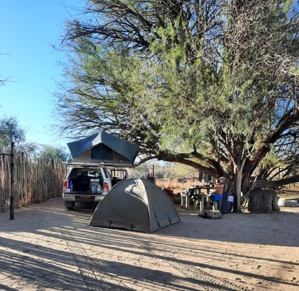 Ein Jeep mit Dachzelt steht hinter einem kleinen aufgebauten Zelt - Namibia Familienurlaub