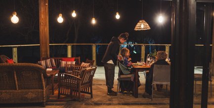 Gäste genießen das Abendessen auf der Terrasse der Kubu Safari Lodge – Südafrika mit Kindern