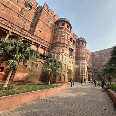 Die beeindruckende rote Sandsteinarchitektur des Agra Forts erhebt sich majestätisch unter einem klaren Himmel.