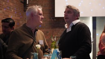 Zwei Männer unterhalten sich bei einer Veranstaltung