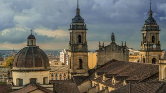 Die beeindruckenden Türme der Kathedrale von Bogotá ragen majestätisch über die Dächer der Stadt, umgeben von dramatischen Wolken.
