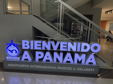 Der leuchtende Willkommensschriftzug "Bienvenido a Panamá" im Flughafenbereich begrüßt die ankommenden Passagiere.