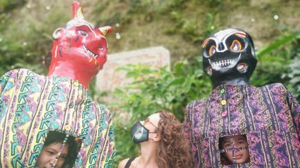 Frau präsentiert farbenfrohe Figuren von Maskenbildner Toni – Costa Rica Familienreise