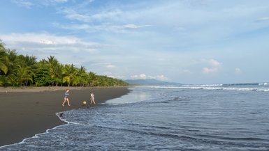 Kinder haben Spaß beim Ballspielen am Strand von Uvita – Costa Rica Familienreise