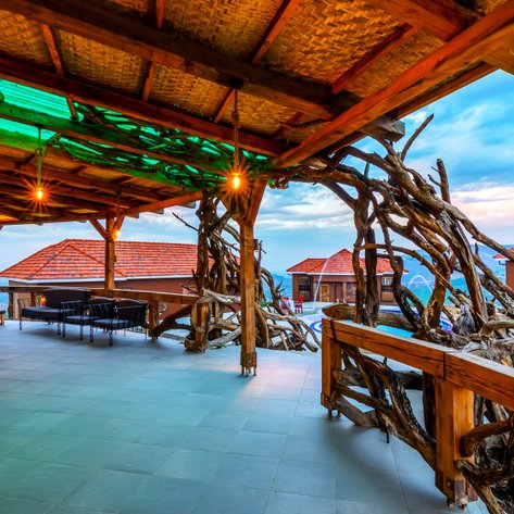 Eine einladende Terrasse mit Holzstruktur und sanfter Beleuchtung, die einen atemberaubenden Blick auf die Landschaft bietet.