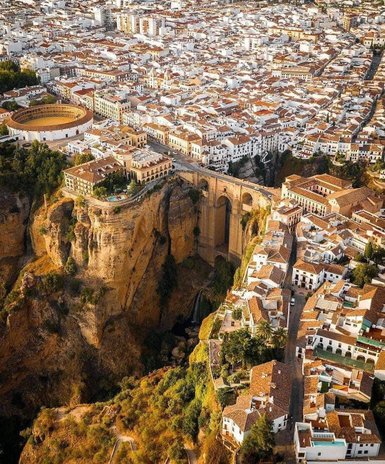 Eine atemberaubende Aussicht auf die Stadt Ronda, mit weißen Häusern und einem beeindruckenden Felsen über einer Schlucht.