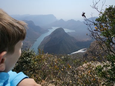 Ein Kind steht am Rand des Blyde River Canyons und blickt fasziniert auf die Landschaft – Südafrika mit Kindern