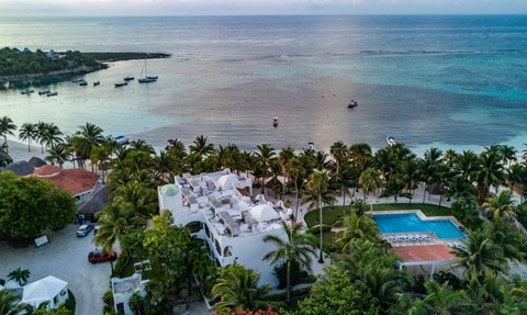Ein atemberaubender Blick auf das ruhige Wasser mit Booten und einer palmengesäumten Küste in einem tropischen Paradies.