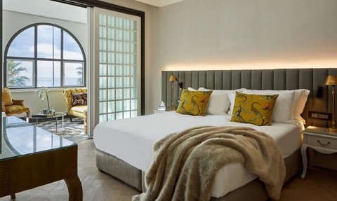 Ein elegantes Hotelzimmer mit einem großen Bett, dekorativen Kissen und einem gemütlichen Überwurf aus Fell.