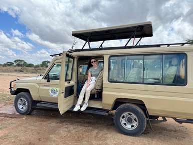 Teenagerin sitzt im Jeep und posiert für ein Foto im Tarangire-Nationalpark – Tansania Reise mit Kindern