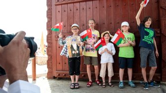 Kinder mit Fahnen werden im Oman fotografiert – Oman Reise mit Kindern