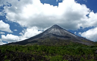 Vulkan Arenal umgeben von grüner Natur und weißen Wolken – Costa Rica Familienreise