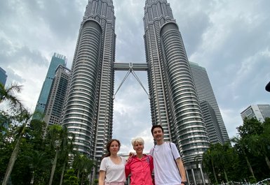 Mutter posiert mit Kindern vor den Petronas Twin Towers in Kuala Lumpur – Malaysia & Borneo Familienreise