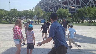 Kinder kicken fröhlich vor dem Nationalstadion „Vogelnest" in Peking – China mit Kindern