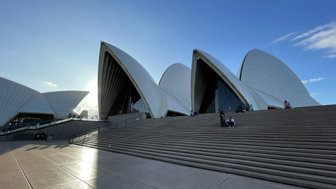 Die beeindruckende Architektur des Sydney Opera House, mit seinen charakteristischen Segel-ähnlichen Dächern, strahlt unter blauem Himmel.