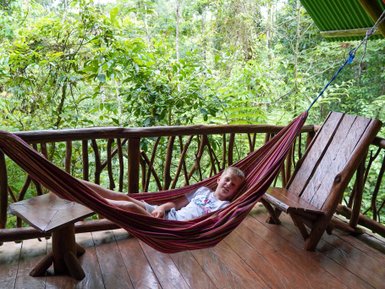 Kind liegt gemütlich in Hängematte im Baumhaus in La Tigra – Costa Rica Reise mit Kindern