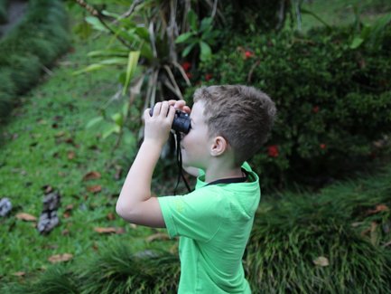 Junge erkundet die Natur mit Fernglas in der Maquenque Eco Lodge – Familienreise Costa Rica