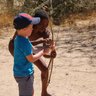 Ein Kind versucht einen Bogen zu spannen - Namibia Urlaub mit Kindern