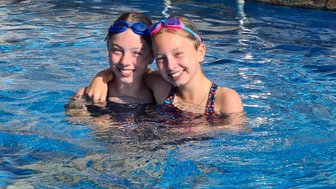 Schwestern genießen gemeinsam das Planschen im Pool – Tansania Familienreise