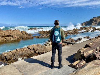 Mann genießt den Ausblick an der Küste von Mossel Bay – Südafrika Familienreise