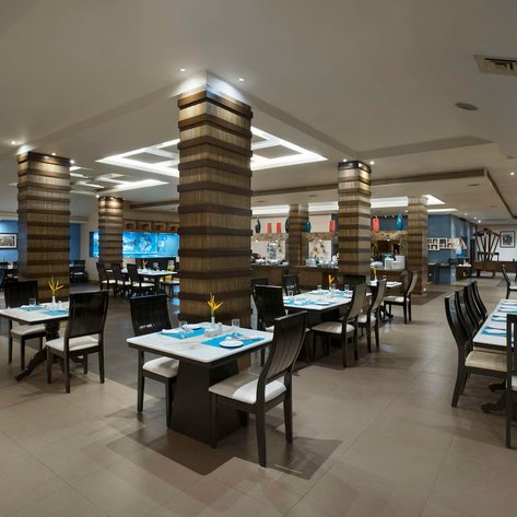 Ein elegantes Restaurant mit modernen Holzmöbeln und blauen Akzenten, das eine einladende Atmosphäre schafft.
